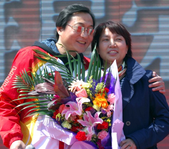 4月24日,中国花样滑冰队主教练姚滨(左)在活动现场与妻子合影